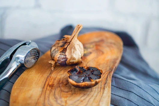 schwarzer Knoblauch auf Holzbrett